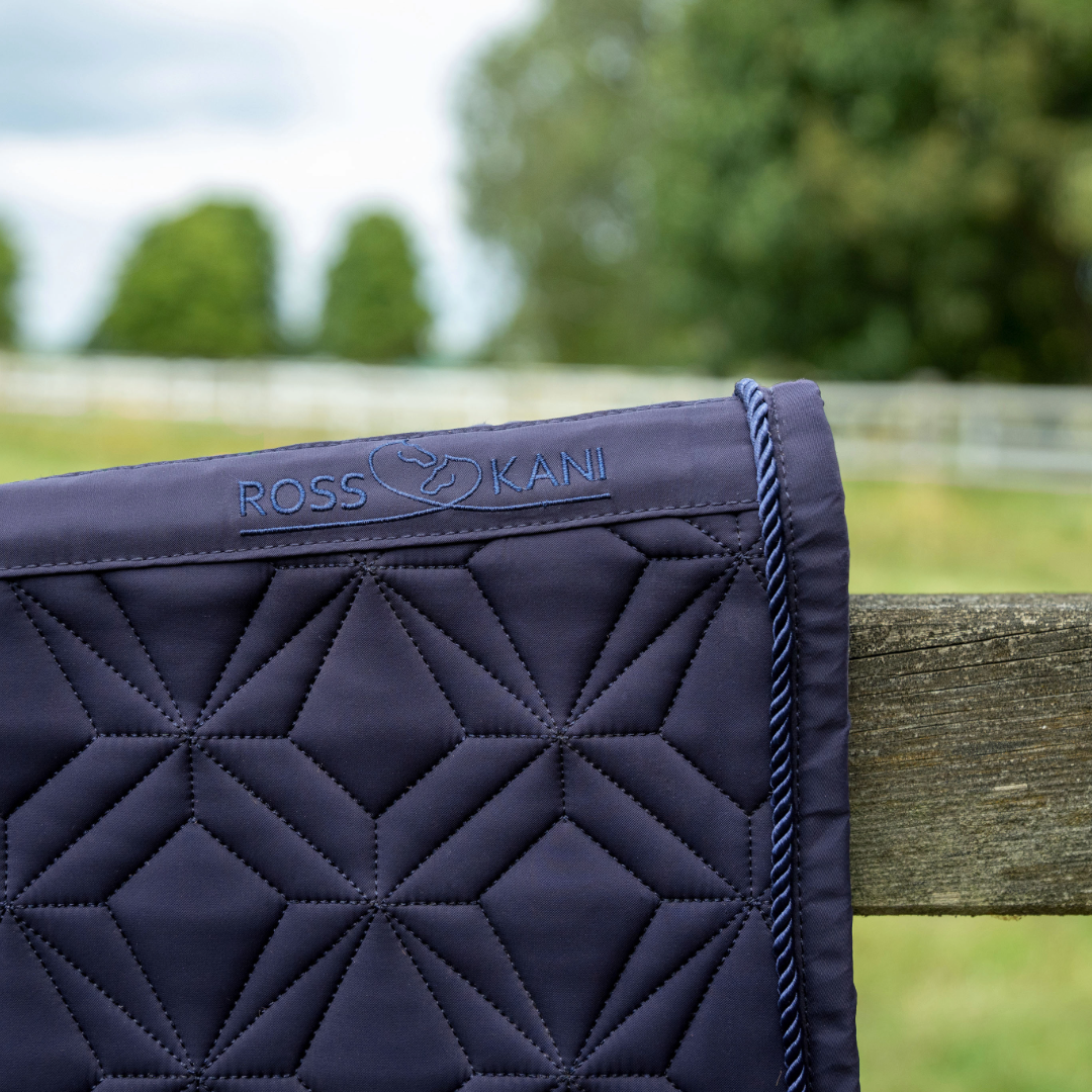 Detailansicht der dunkelblauen ROSS KANI Classic Dressur-Schabracke mit Logo, Diamant-Steppung und Kordel-Einfassung