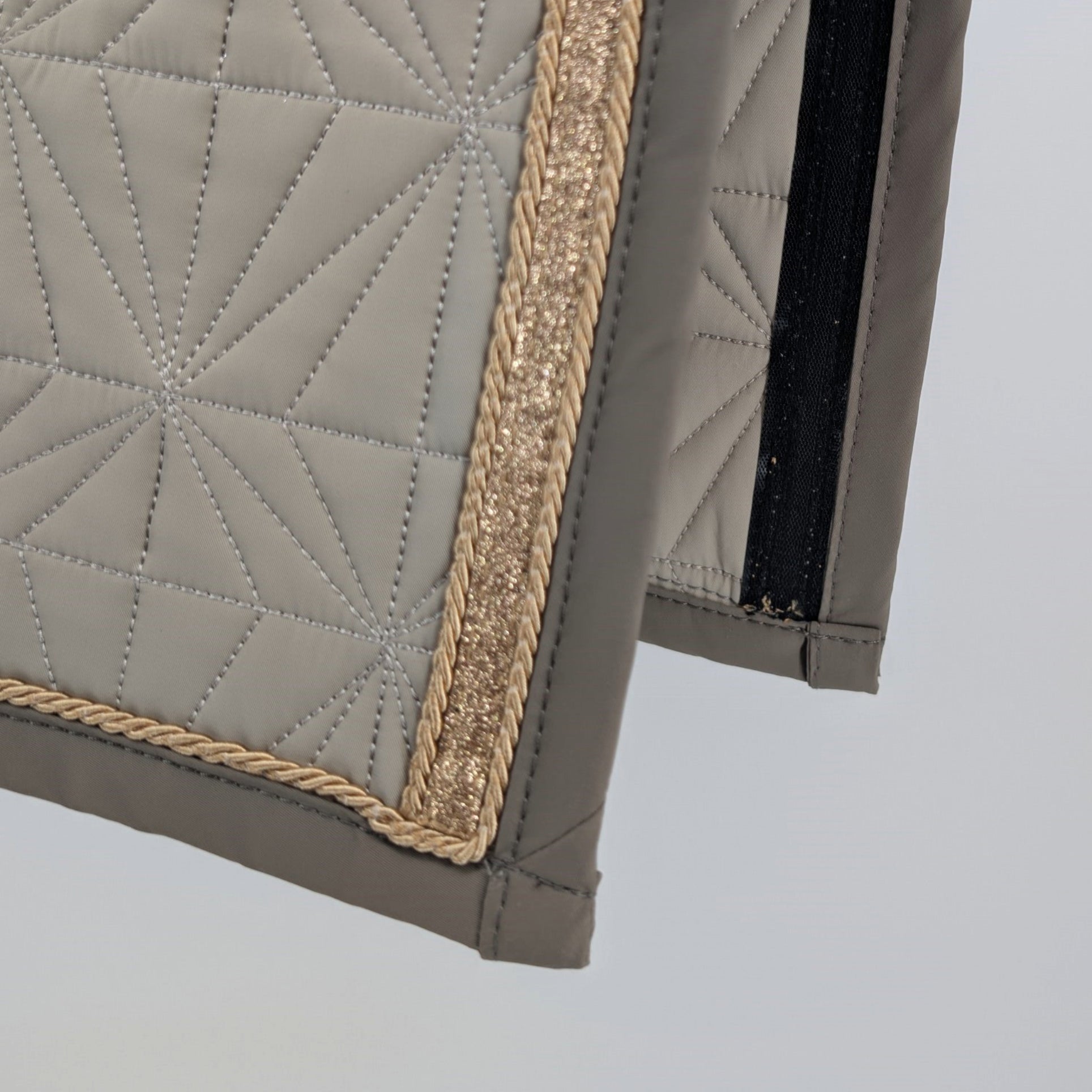Detailansicht der Innenseite des beigen ROSS KANI Schabracken-Cover – Brilliant Steppung, goldene Kordel, goldenes Glitzerband.
