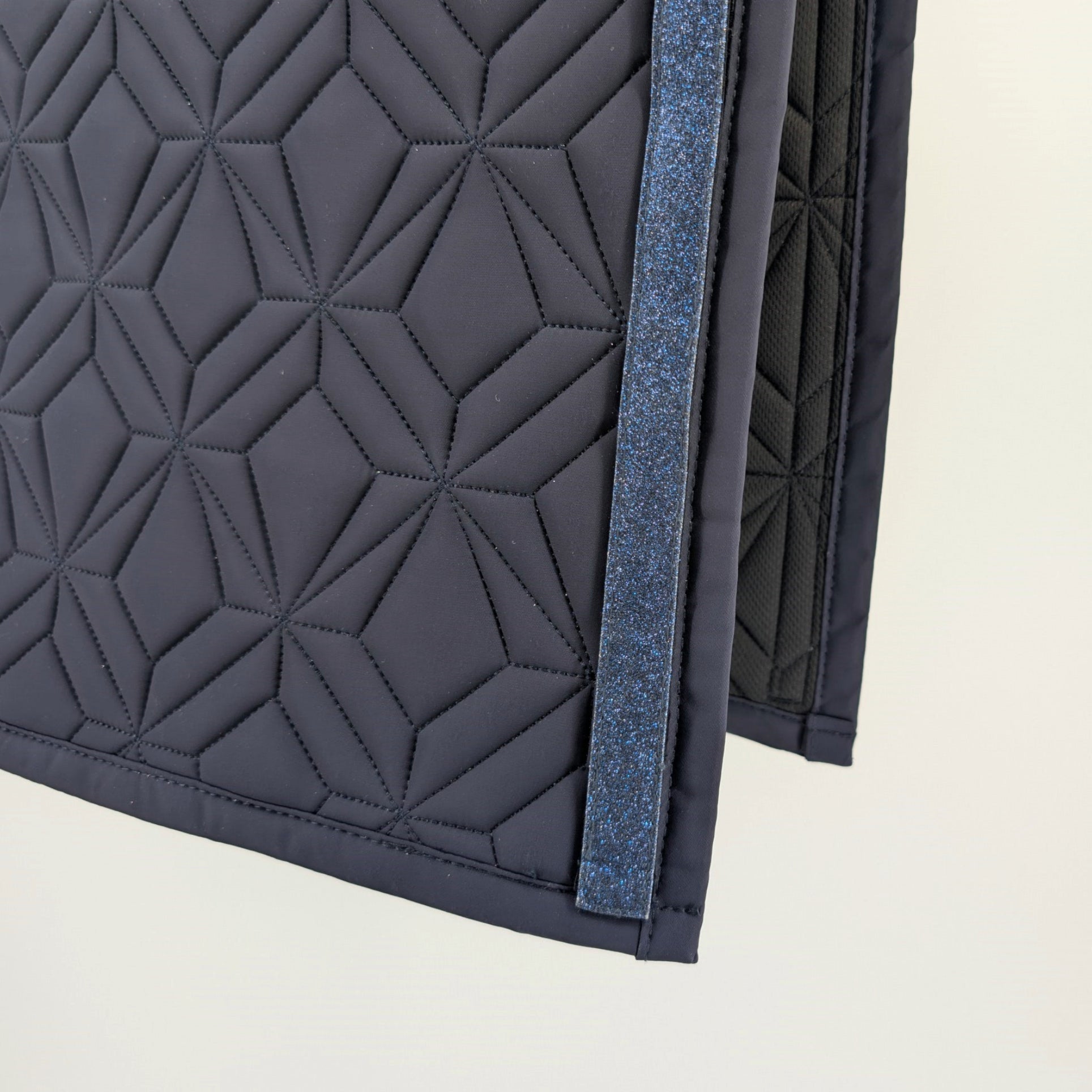 Detailansicht der Innenseite der blauen Schabracke von ROSS KANI – Diamant Steppung, blaues Glitzerklettband.