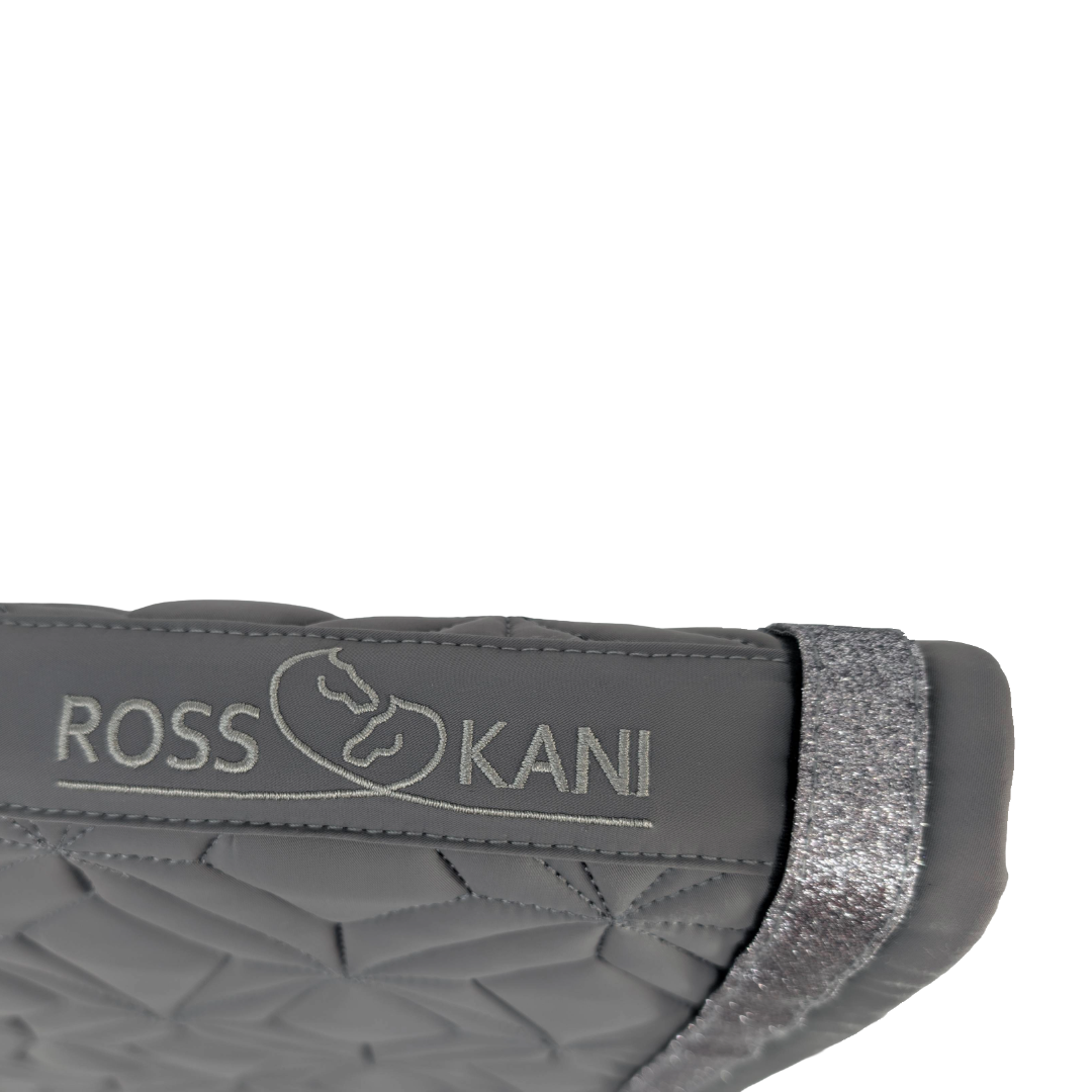 Detailaufnahme des gesteppten ROSS KANI Logos auf der grauen Schabracke – hochwertig verarbeitet.