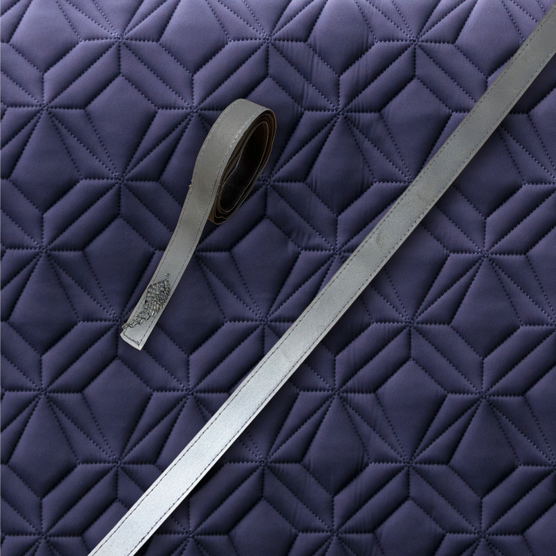 Reflektierende Klettbänder mit Engelflügel-Charm auf der blauen Schabracke für den Reitsport – hochwertiges, strapazierfähiges Klettband zur sicheren Befestigung an Schabracken von ROSS KANI, ideal für Sichtbarkeit in der dunklen Jahreszeit.