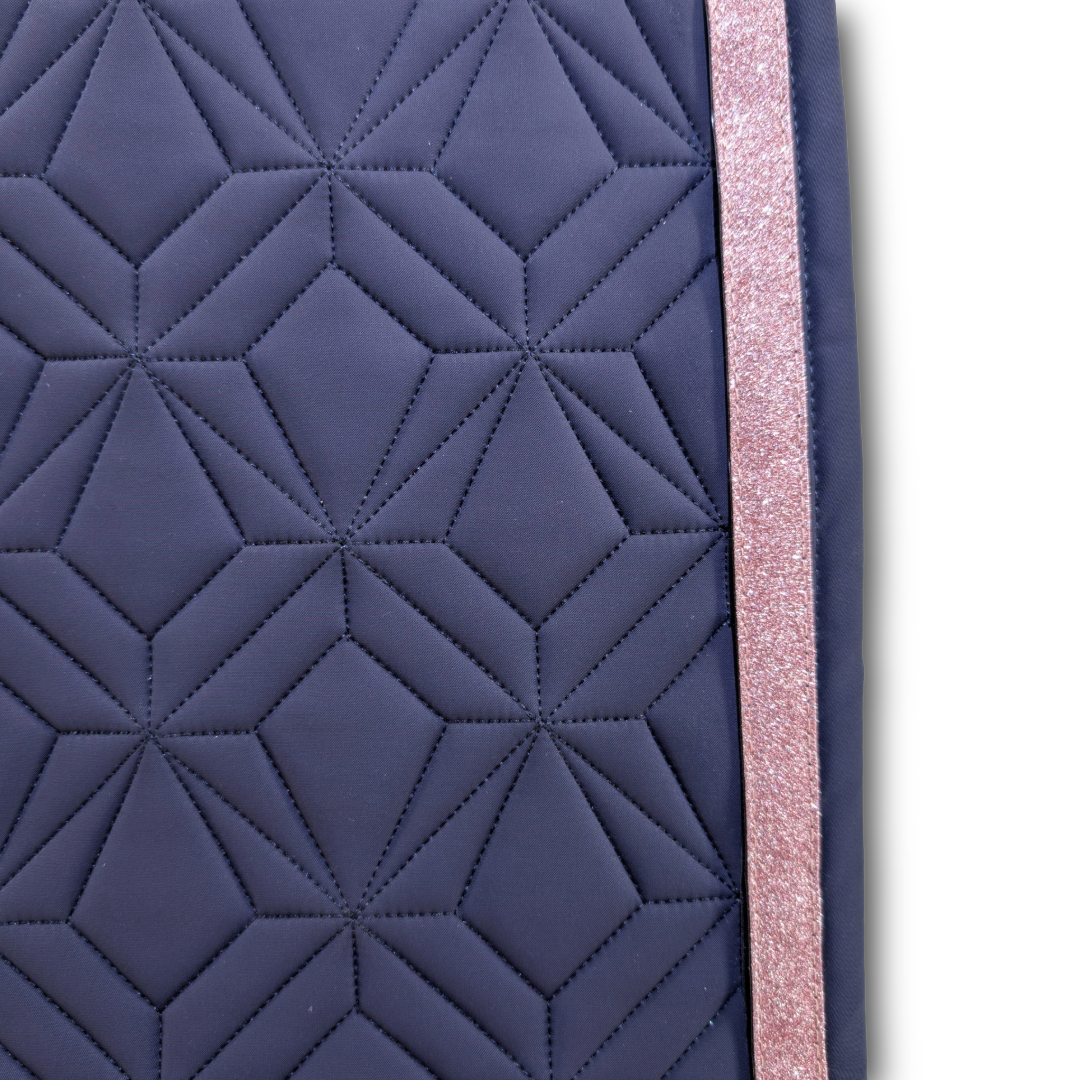 Detailansicht der navyfarbenen ROSS KANI Schabracke mit geometrischem Steppmuster und rosa Glitzerband – elegantes Design für stilbewusste Reiterinnen.