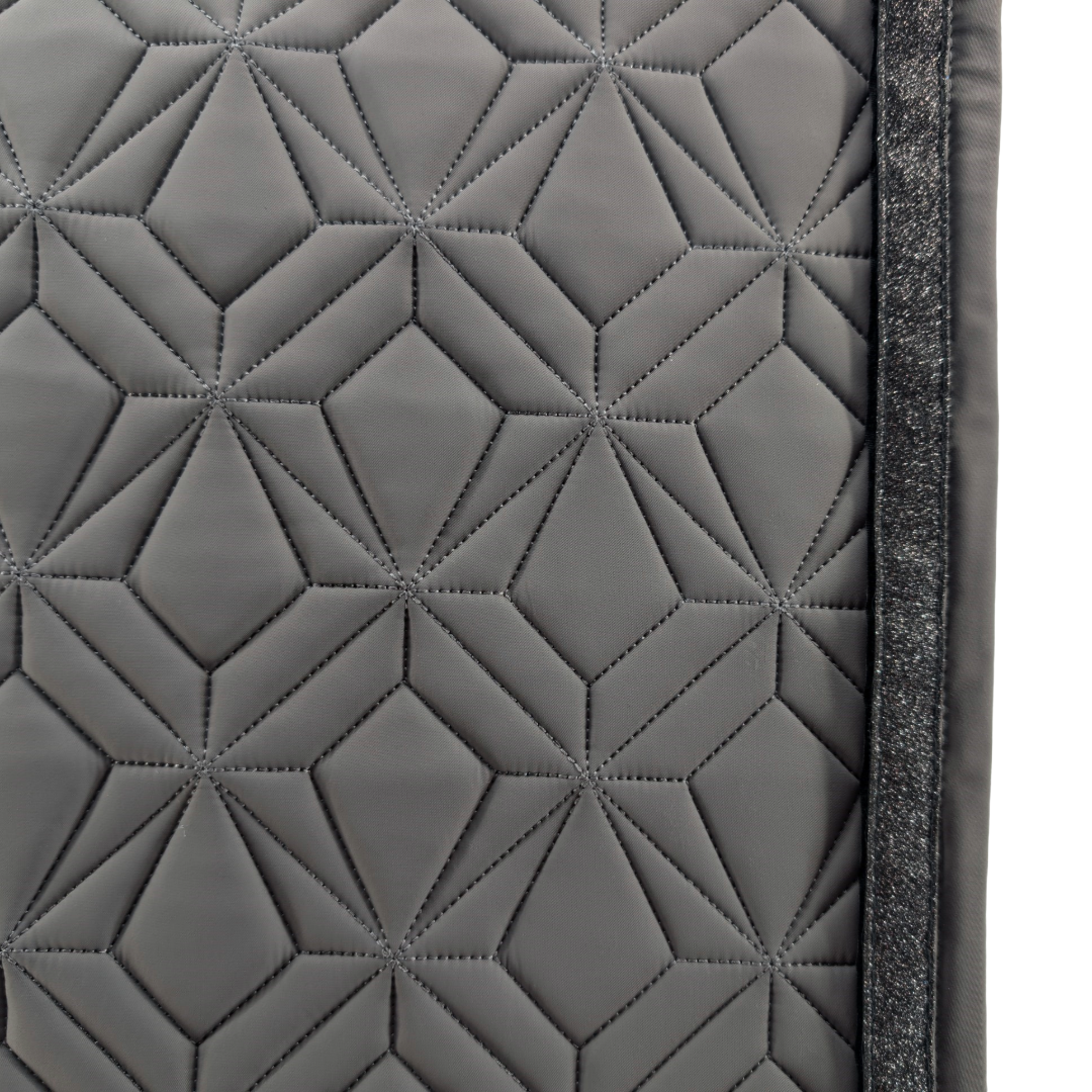Detailansicht der graufarbenen ROSS KANI Schabracke mit geometrischem Steppmuster und schwarzem Glitzerband – elegantes Design für stilbewusste Reiterinnen.