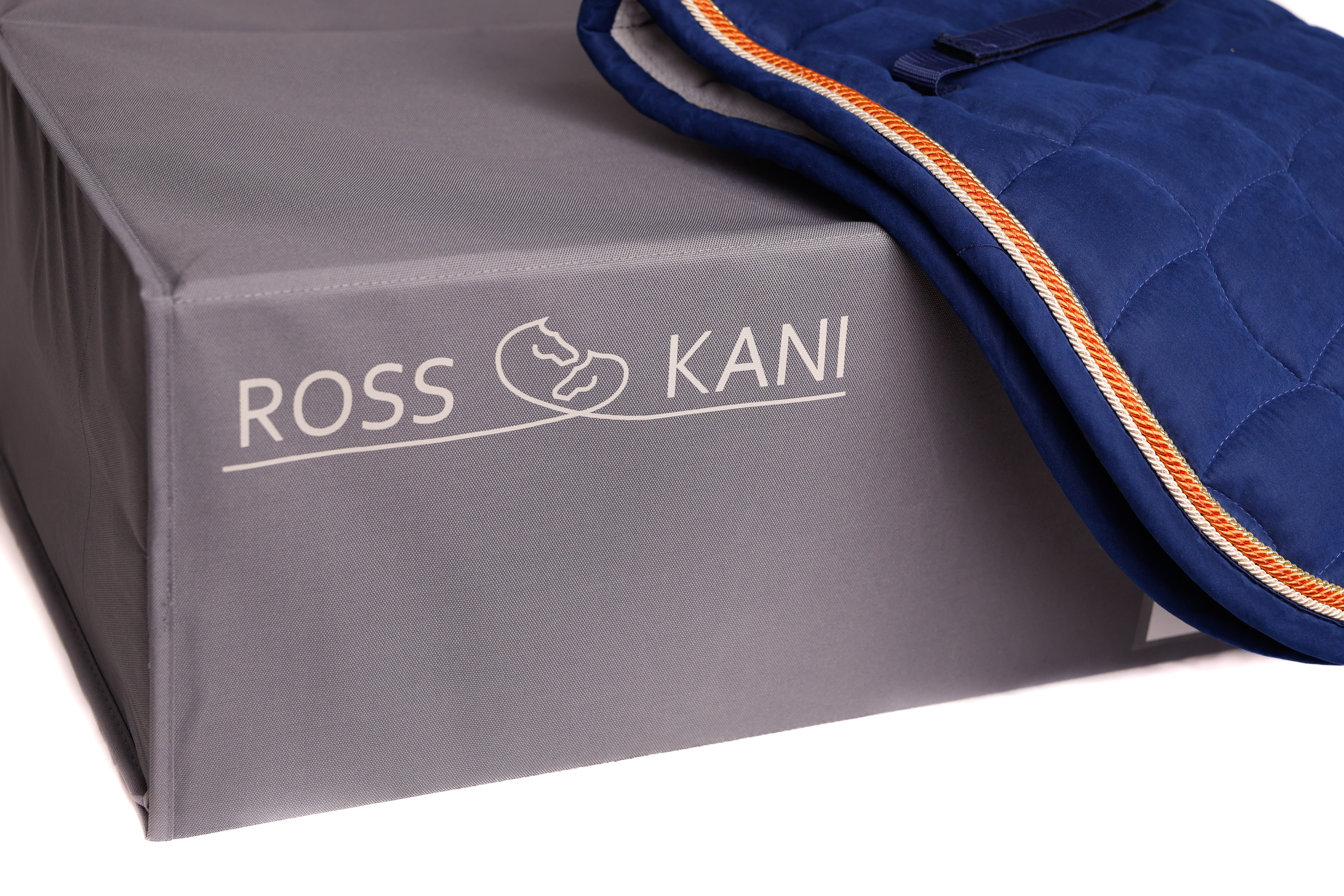 ROSS KANI Schabrackenbox in Grau mit aufliegender navyblauer Schabracke – hochwertige Aufbewahrungslösung für Reitzubehör mit elegantem Logo und praktischem Design.