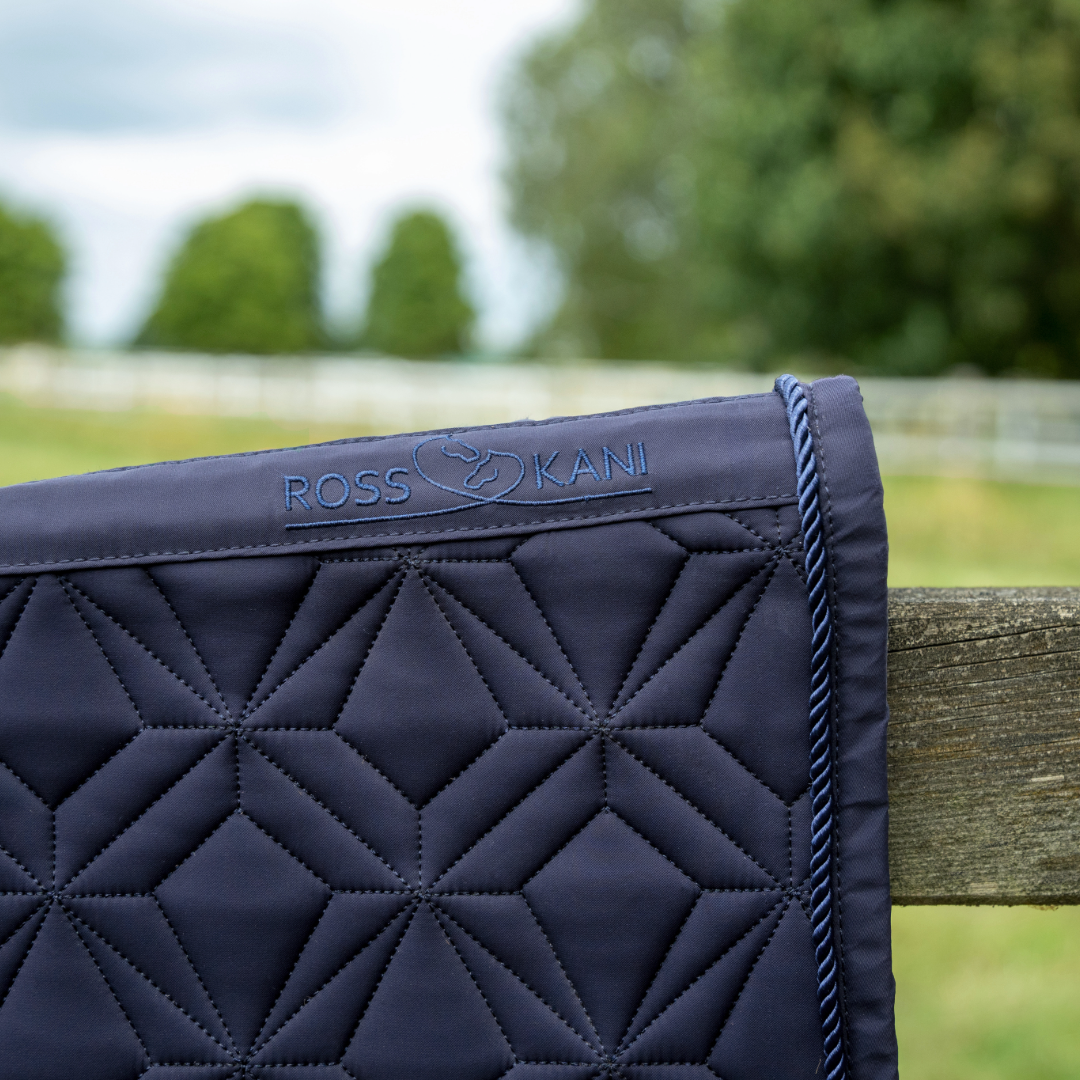 Detailansicht der dunkelblauen ROSS KANI Classic Dressur-Schabracke mit Logo, Diamant-Steppung und Kordel-Einfassung