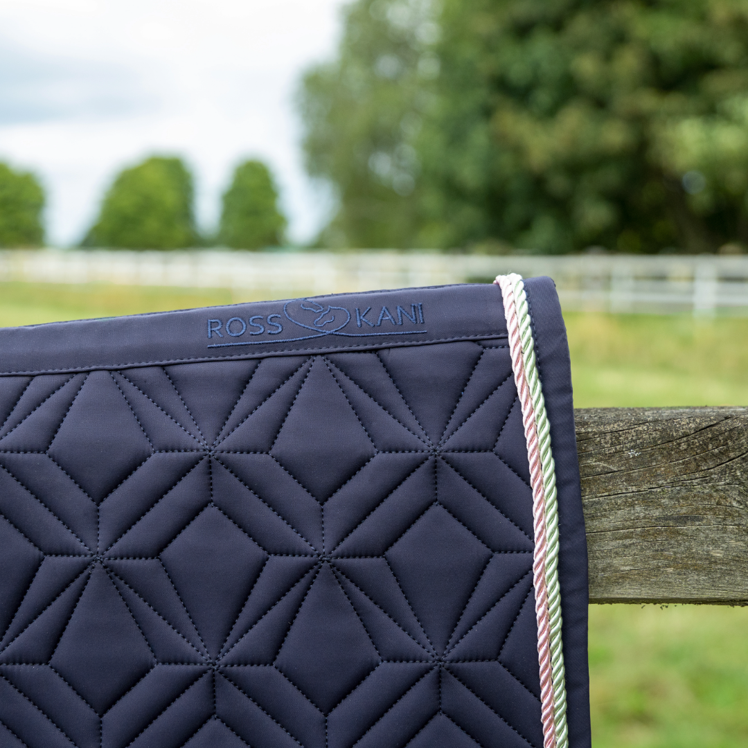 Detailansicht der dunkelblauen ROSS KANI Classic Spring-Schabracke mit Logo, Diamant-Steppung und zweifarbiger Kordel-Einfassung