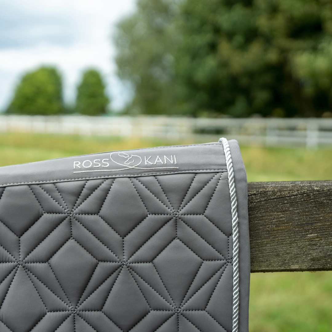 Detailansicht der grauen ROSS KANI Classic Springschabracke mit Logo, Diamant-Steppung und silberner Kordel