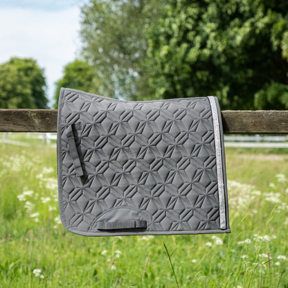 Graue ROSS KANI Dressurschabracke in Seitenansicht – einzigartige Steppung und perfekte Passform.