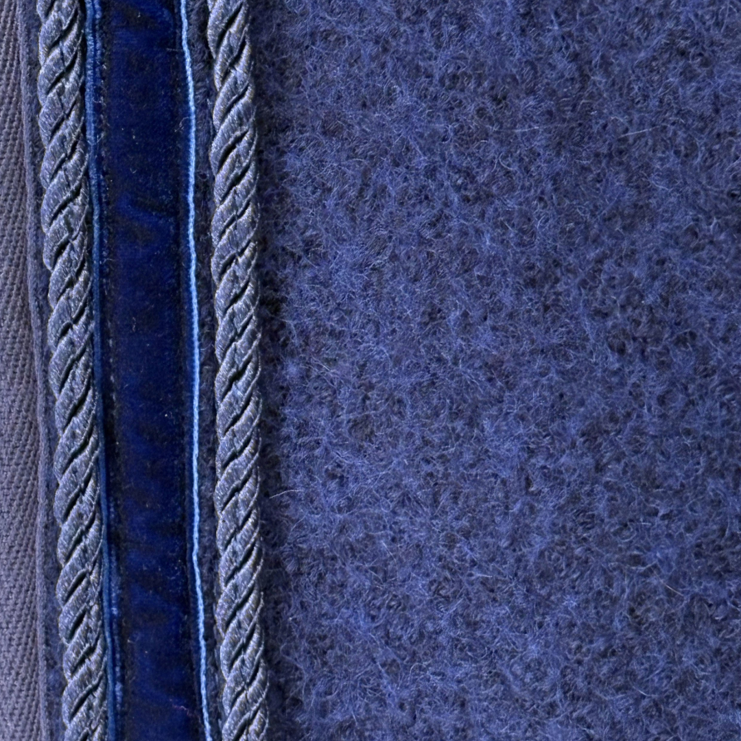 Detailansicht der blauen ROSS KANI Ausreitdecke aus Wollwalk; natürliches, temperaturregulierendes Material, atmungsaktiv und wärmend für den Einsatz bei wechselnden Bedingungen.