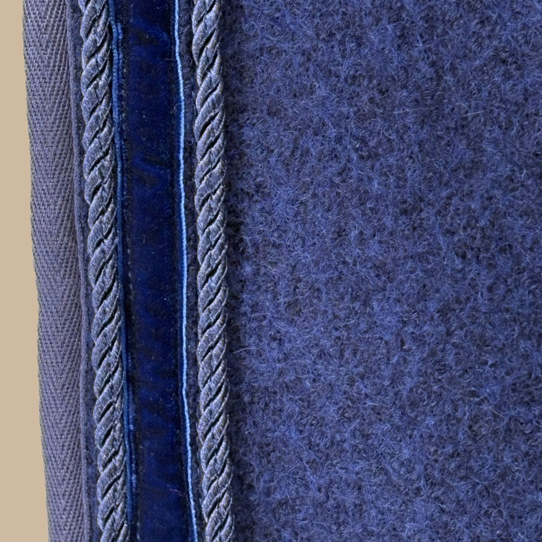 Detailansicht der blauen ROSS KANI Ausreitdecke aus Wollwalk; natürliches, temperaturregulierendes Material, atmungsaktiv und wärmend für den Einsatz bei wechselnden Bedingungen.