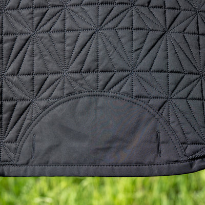 Detailansicht des schwarzen ROSS KANI Schabracken-Covers mit geometrischem Steppmuster und robusten Gurtschlitzen – elegantes und funktionales Reitzubehör.