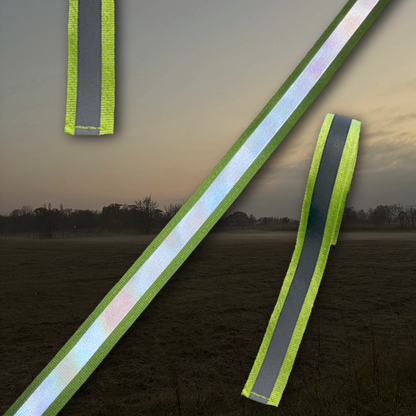 Reflektierende Bänder in Neonfarbe von ROSS KANI vor einemnebelig dunklem Hintergrund. Die schmalen Bänder zeigen eine helle, reflektierende Mittelstreifenfläche mit neonfarbenen Kanten.