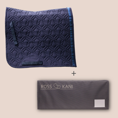 Blaue Dressurschabracke mit Diamantsteppung und Aufbewahrungsbox für Schabracken von ROSS KANI vor roséfarbenem Hintergrund.