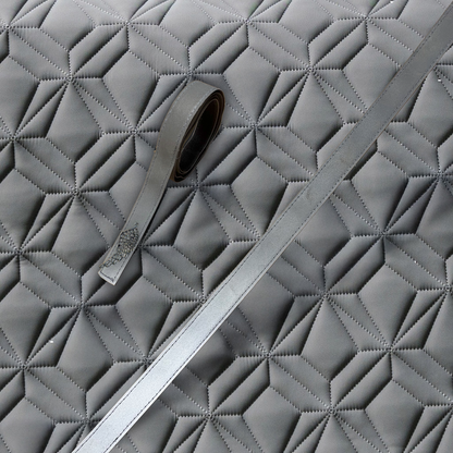 Reflektierende Klettbänder mit Engelflügel-Charm auf der grauen Schabracke für den Reitsport – hochwertiges, strapazierfähiges Klettband zur sicheren Befestigung an Schabracken von ROSS KANI, ideal für Sichtbarkeit in der dunklen Jahreszeit.