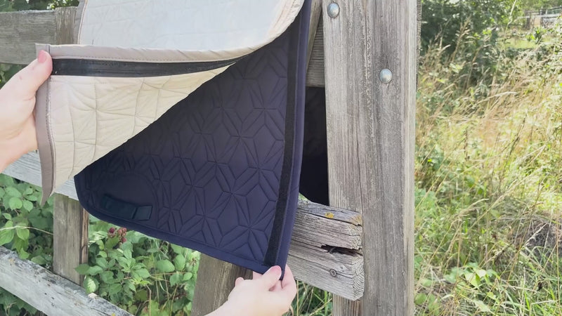 Video: Beiges Spring-Cover von ROSS KANI wird auf der blauen Schabracke befestigt – einfache Handhabung. Die Schabracke hängt über einem Koppelzaun und im Hintergrund sieht man Wiese.