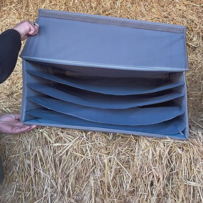 Video: Aufbewahrungsbox im Stall: leere Box wird zusammengeklappt und anschließend gefüllt mit Schabracken wieder aufgeklappt, liegend im Stroh.
