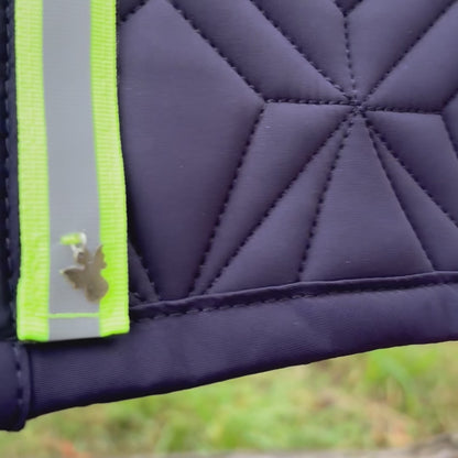 Video: Reflektierendes Neonklettband mit Schutzengel-Charm von ROSS KANI wird auf der blauen Schabracke befestigt – einfache Handhabung.