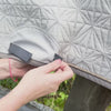 Video: Die graue Spring-Hauptschabracke von ROSS KANI hängt über einem Koppelzaun. Das beige Spring-Cover wird aufgeklettet. Im Hintergrund sieht man ein bisschen Wiese.