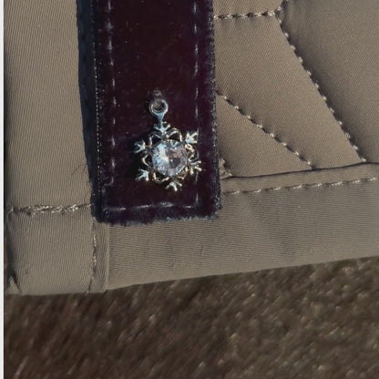 Video: Dunkelblaues Samtband mit Schneeflocken-Charm von ROSS KANI wird auf der grauen Schabracke befestigt – einfache Handhabung.